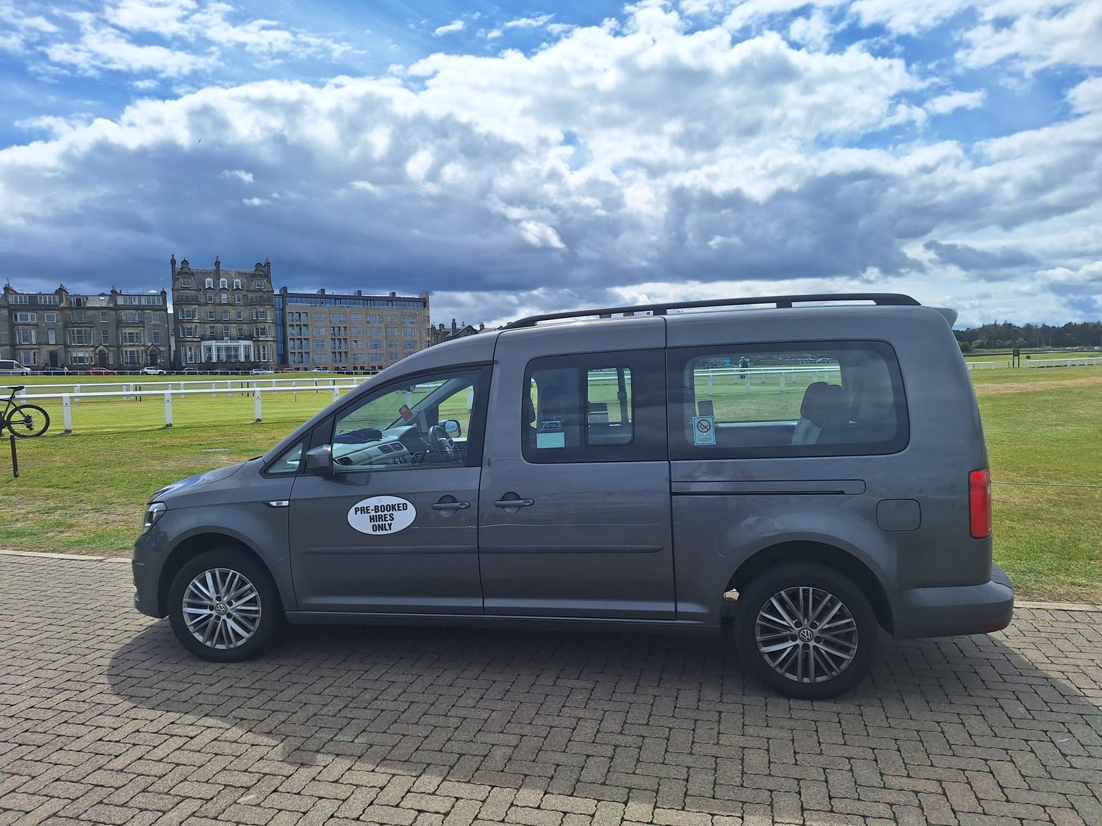EdiVentures tour vehicle parked in front of the iconic Old Course Hotel in St Andrews, Scotland, offering tailored Scottish adventure tours